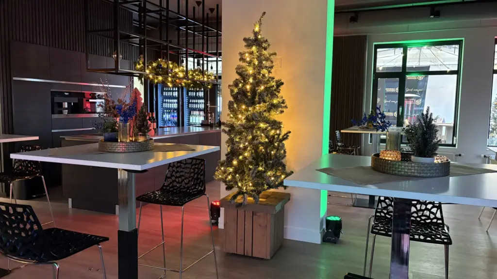 Kerstborrel op locatie met verlichte kerstboom en statafels
